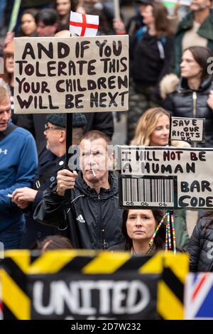 Protesters hold up signs amongst marching crowd during an anti-lockdown rally in London, 24 October 2020 Stock Photo