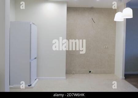 Empty space with a niche for the kitchen. Refrigerator, sockets and lamps Stock Photo