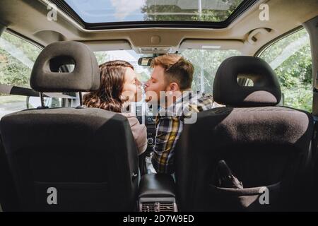 man with woman kissing in car Stock Photo
