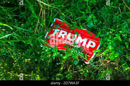 A political campaign sign for Donald J. Trump during the 2020 race for U.S. President has been discarded in the weeds on the west coast of Florida. That is one of the battleground states that determines who wins the four-year presidential office in a prolonged election season that pitted the Republican incumbent Trump against his Democratic party rival, Joseph R. Biden, Jr. Joe Biden was eventually the victor in the hard-fought contest. He previously served as the American vice president under Barack Obama for two terms from 2009 to 2017. Stock Photo