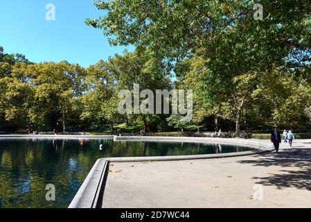 Conservatory Water is model boat pond in Central Park in Manhattan, New York City. Located in a natural hollow, the landscape slopes up on the sides. Stock Photo
