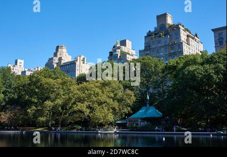 Conservatory Water is model boat pond in Central Park in Manhattan, New York City. Beyond the trees are apartment buildings on Fifth Avenue Stock Photo