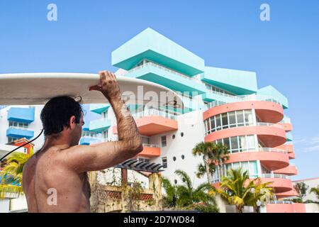 Miami Beach Florida,South Beach,Ocean Drive,surfer surfboard carrying balancing head,condominium building residences, Stock Photo