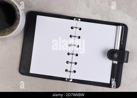 Flat Lay still life of a business desk with Coffee Cup, and small ring binder open to blank pages Stock Photo