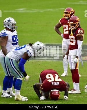 Landover, United States. 25th Oct, 2020. Dallas Cowboys defensive end DeMarcus Lawrence (90) checks on injured Washington Football Team offensive tackle Morgan Moses (76) during the second half of an NFL football game at FedEx Field in Landover, Maryland, on Sunday, October 25, 2020. Washington won 25-3. Photo by David Tulis/UPI Credit: UPI/Alamy Live News Stock Photo