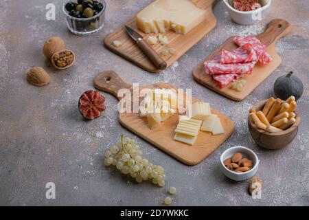 Assorted cheese, salumi, nuts on wooden boards, copy space Stock Photo