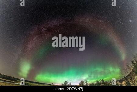 Rare amazing photo of whole Milky Way panorama matching Aurora Borealis red part (Steve phenomenon), green lights below, Northern Sweden landscape. 23 Stock Photo