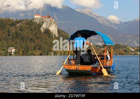 Tourists travelling by traditional pletna on Lake Bled in Slovenia Stock Photo