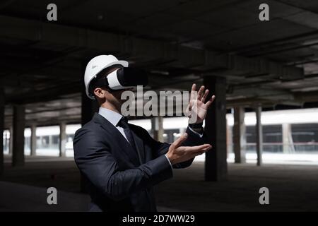 Dramatic waist up portrait of businessman wearing VR gear at construction site while visualizing future project in 3D, copy space Stock Photo