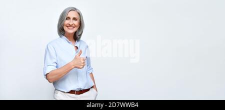 Smiling mature business woman showing thumbs up on background, banner. Stock Photo