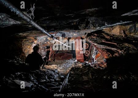 Overturned wagon on a steep railed incline in Cwmorthin slate mine, North Wales. Stock Photo