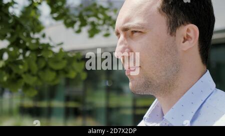 Handsome man walking along the office building. Stock Photo