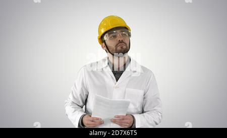 Site engineer cheching papers and something around him on gradie Stock Photo