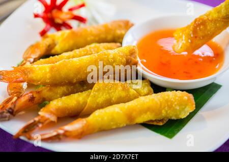 Prawn spring rolls dipping in sweet chilli sauce Stock Photo