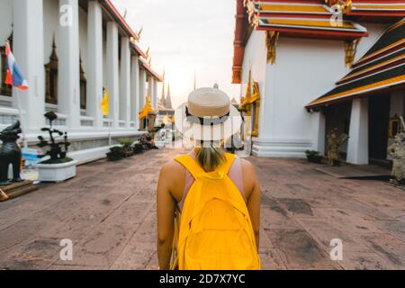 Young woman travel to Thailand with backpack and hat walking in Wat Pho at Bangkok Thailand Stock Photo