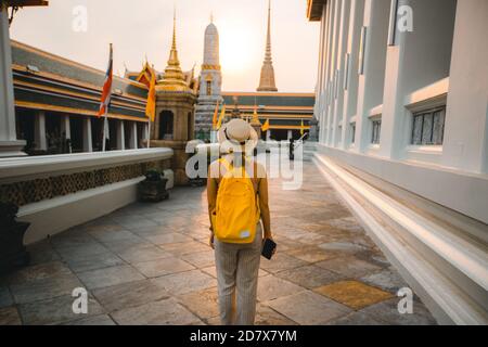 Young woman travel to Thailand with backpack and hat walking in Wat Pho at Bangkok Thailand Stock Photo