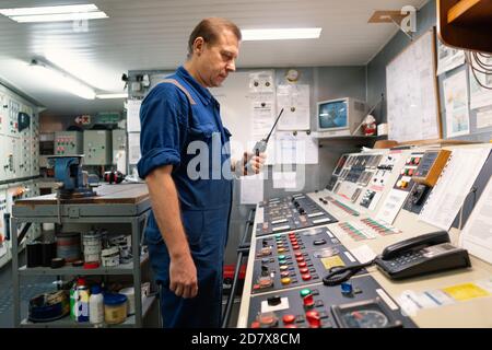 Marine Engineer working on radio communication at Engine Control room ECR Stock Photo