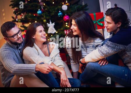 Group of friends with presents celebrating Christmas at home Stock Photo