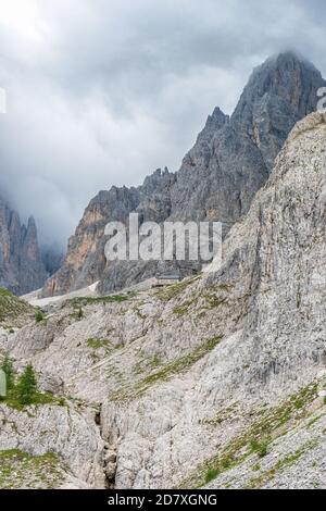 Mountain hut on a rock shelf in rocky wild landscape Stock Photo