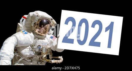 Astronaut in space holding a 2021 white  board - New year greeting card - elements of this image are provided by NASA Stock Photo