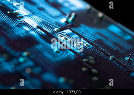 Blue electronic circuit board with many electrical components, isolated on black background Stock Photo