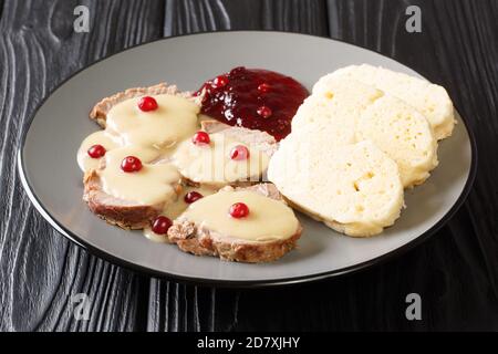 Czech Braised Beef In Spiced Cream Sauce With bread dumplings svickova na smetane  close-up in a plate. Horizontal Stock Photo