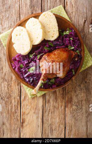 Bohemian baked duck leg served with red cabbage and bread dumplings close-up in a plate on the table. vertical top view from above Stock Photo