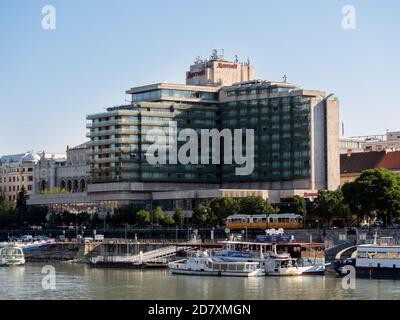 BUDAPEST, HUNGARY -  JULY 16, 2019:  View of the Marriott Hotel from the Danube River with tour boats moored in the foreground Stock Photo