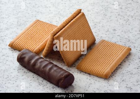Rectangular shortbread cookies and chocolates on a light marble top. Stock Photo