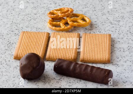 Rectangular shortbread cookies and chocolates on a light marble top. Stock Photo