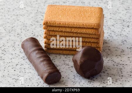 Rectangular shortbread cookies and chocolates on a light marble top. Stock Photo