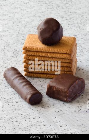 Rectangular shortbread cookies and chocolates on a light marble top. Stock Photo