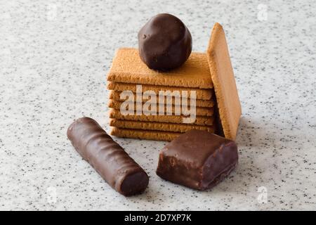 Rectangular shortbread cookies and chocolates on a light marble top. Stock Photo