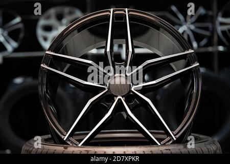 sports alloy wheel rim with carbon cover, in the hall of the car shop on the background of wheels. Front view Stock Photo