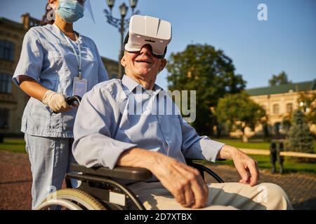 Male patient with virtual reality glasses sitting in a wheelchair Stock Photo