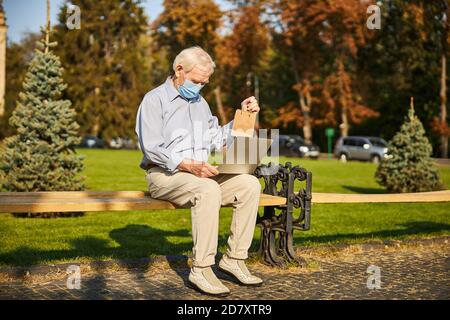 Senior man using laptop while looking at screen Stock Photo