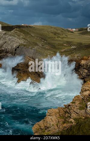 A beautiful scenery of rocky cliffs by the sea under a cloudy sky. Big wave. Stock Photo
