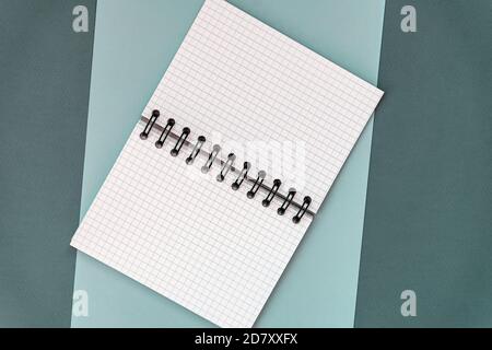 Open squared notebook on spiral on colorful blue turquoise background, flat lay, copy space Stock Photo