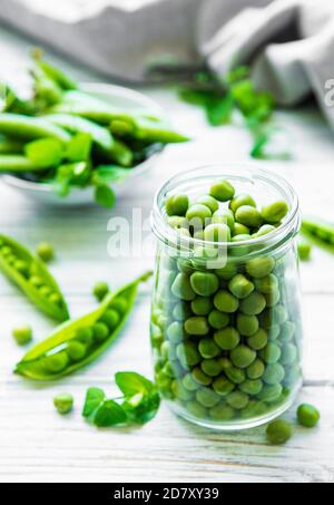 Healthy food. Fresh green peas in open glass jar  on wooden background Stock Photo