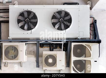 The compressor unit and air conditioners are installed on a metal frame and fixed to the wall of the old building. Stock Photo