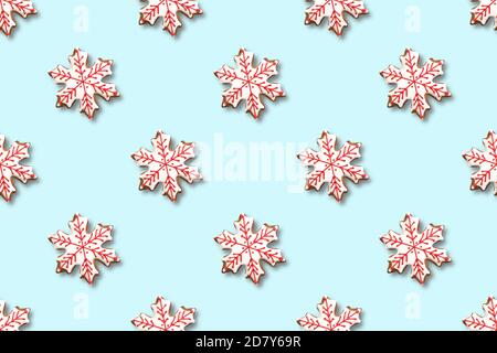 Seamless pattern of Christmas gingerbread in shape snowflake on blue background. Xmas abstract background. Stock Photo
