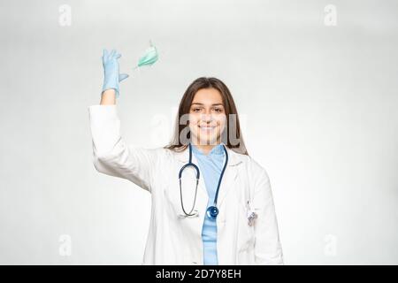 Smiling female young european doctor throw away mask after successfully defeating the coronavirus. Stock Photo