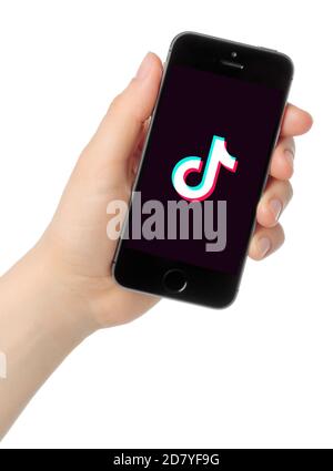 Kiev, Ukraine - August 25, 2020: Hand holds iPhone 5s with TikTok logo on white background. TikTok is a video-sharing social networking service owned Stock Photo