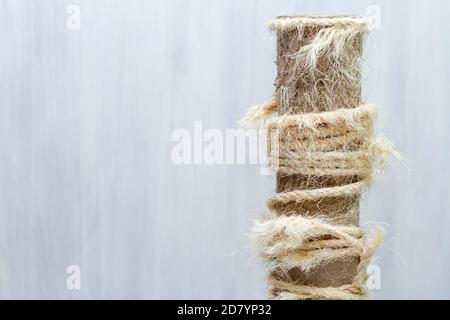 used scratching post with torn ropes, old cat tree on white background, copy space for text Stock Photo