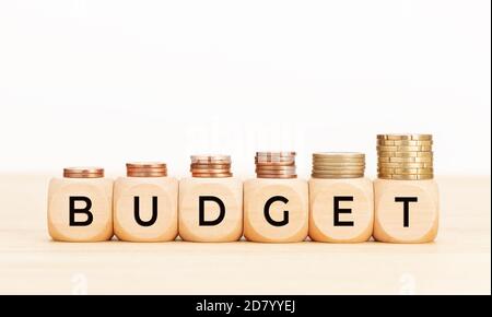 Budget word on wooden blocks and coins on table. White background. Copy space Stock Photo