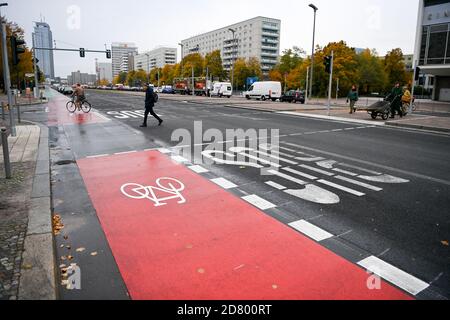 Berlin, Germany. 26th Oct, 2020. The redesigned Karl-Marx-Allee with wide cycle lanes, better crossing possibilities for pedestrians and a soon to be greened central reservation has been completed and was handed over today after a 28-month construction period. The reconstruction of the main road between Strausberger Platz and Otto-Braun-Straße was carried out in favour of pedestrian and bicycle traffic. Instead of parking spaces, there is a green area in the middle of Karl-Marx-Allee, for example. Credit: Jens Kalaene/dpa-Zentralbild/ZB/dpa/Alamy Live News