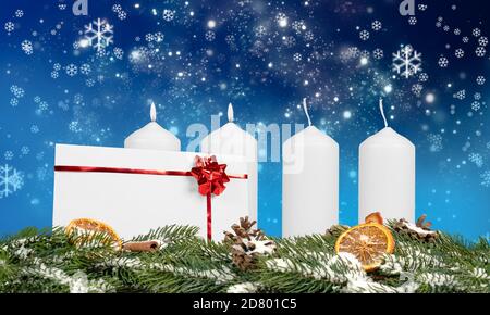 two burning advent candles on an advent arrangement with envelope and decoration on blue background Stock Photo