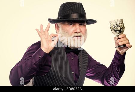 Trick or Treat. barman make cocktail for halloween party. halloween holiday costume. evil wizard cooking magic potion with spider. happy halloween. mature man magician in witch hat. Stock Photo
