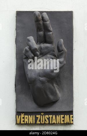 Memorial plaque devoted to the fallen during the Prague Uprising in May 1945 placed on the wall of a house in Masarykovo Embankment in Nové Město (New Town) in Prague, Czech Republic. The iconic blessed hand with the Czech inscription 'Věrni zůstaneme' ('We shall remain faithful') was designed by Czech modernist sculptor Karel Pokorný (1945). Stock Photo