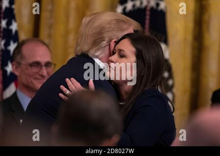 U.S. President Donald Trump embraces outgoing White House Press Secretary Sarah Huckabee Sanders as delivers remarks about prison reform in the East Room of the White House in Washington, D.C. on June 13, 2019. Sanders announced today that she will be leaving the White House at the end of the month. Credit: Alex Edelman/The Photo Access Stock Photo